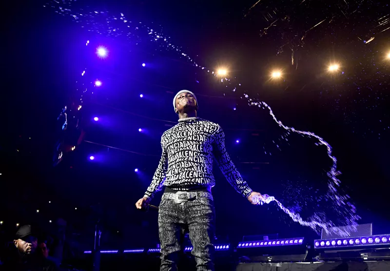 Image: DaBaby throws water on the audience during his performance at the 2020 EA Sports Bowl at American Airlines Arena.