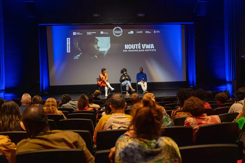 Image: a panel sits on a stage in front of an audience after a movie screening