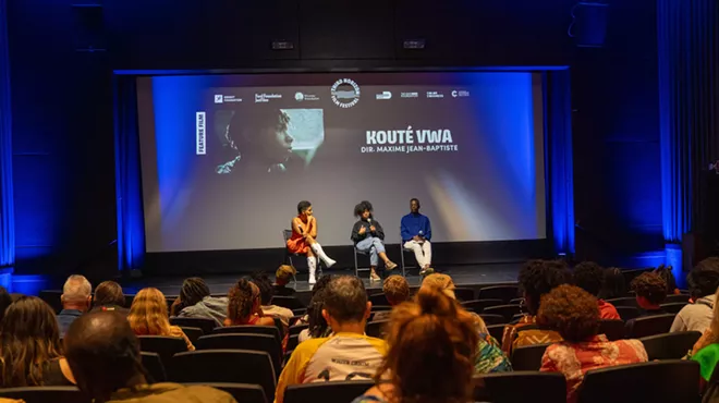 a panel sits on a stage in front of an audience after a movie screening