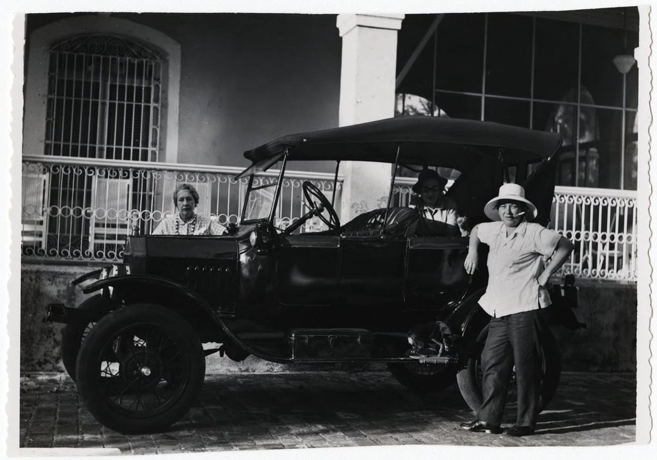 Lydia Cabrera (behind the car) and Josefina Tarafa (standing in front of the car), ca. 1957.