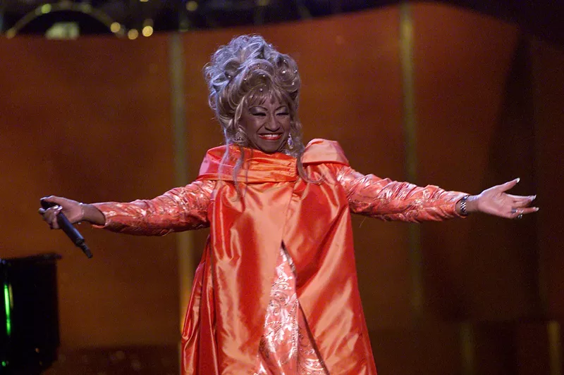 Image: Celia Cruz on stage wearing a red dress