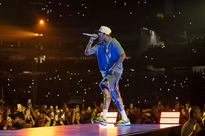 Image: A man singing with a mic on stage in front of a crowd.