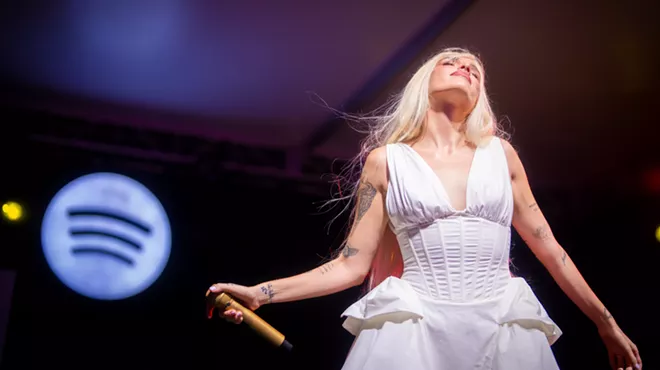 Picture of singer Elena Rose on stage wearing a white dress.