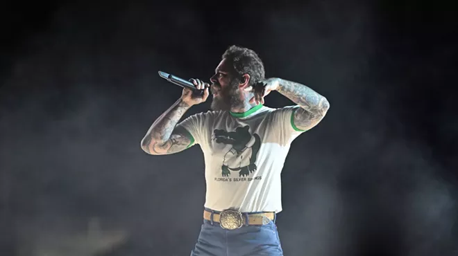 Post Malone performs in jeans and a Silver Springs Florida T-shirt featuing a cartoon alligator
