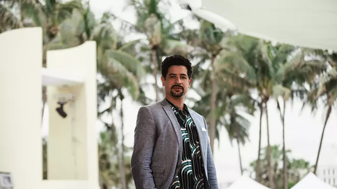Adam Ganuza in a blazer in front of palm trees