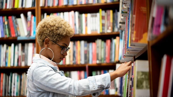 Woman browsing through bookshelves at a library