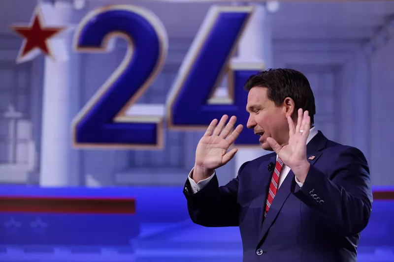 Image: Florida Gov. Ron DeSantis raises his open hands during a town hall event in January 2024.