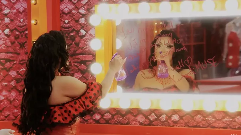 Image: Morphine Love Dion cleaning a message written lip stick from a mirror