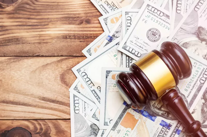 Image: Stock photo of a judge's gavel on a pile of money