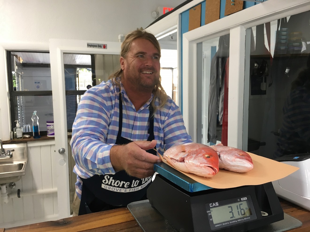 Shore to Door owner Sig Ozols weighs a pair of snapper.