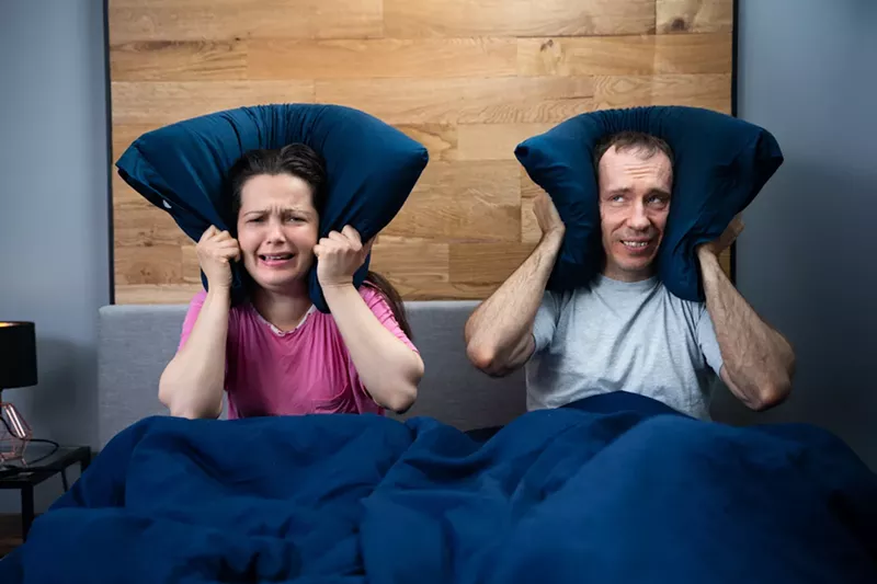 Image: "Loud Neighbor Making Noisy Party While Couple Sleeping In Bed" is a stock photo. Miami Springs residents say they lived it last weekend.