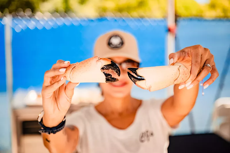Image: a person holding a stone crab