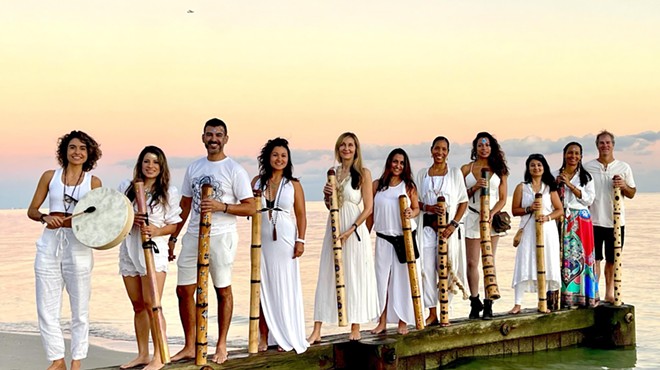 The members of the South Beach Sound Healing Orchestra standing on a dock