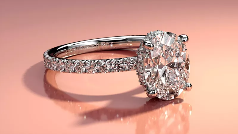 Image: close-up image of a diamond ring with a pink background