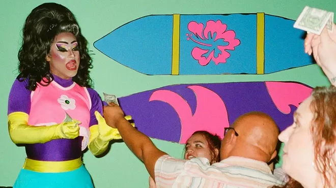 a drag queen performs in front of an audience and gets tips