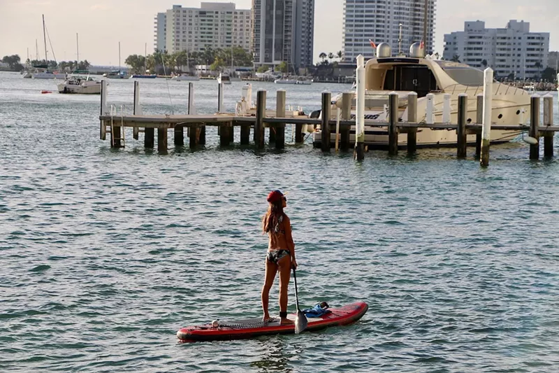 Image: A woman takes a sunset paddle off of West Avenue.