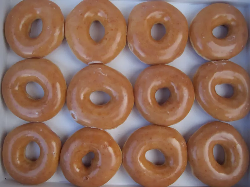 Image: A dozen Krispy Kreme glazed doughnuts cost only 80 cents after you buy the first dozen at regular price.