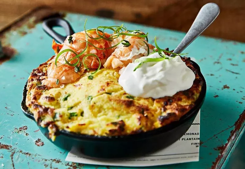 Image: Sweet corn spoon bread loaded with buttermilk cream, scallions, and butter-poached lobster.