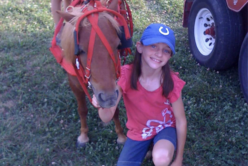 Image: Keirstyn Bucy, as a child in Indiana, posing with her horse before an equestrian show.