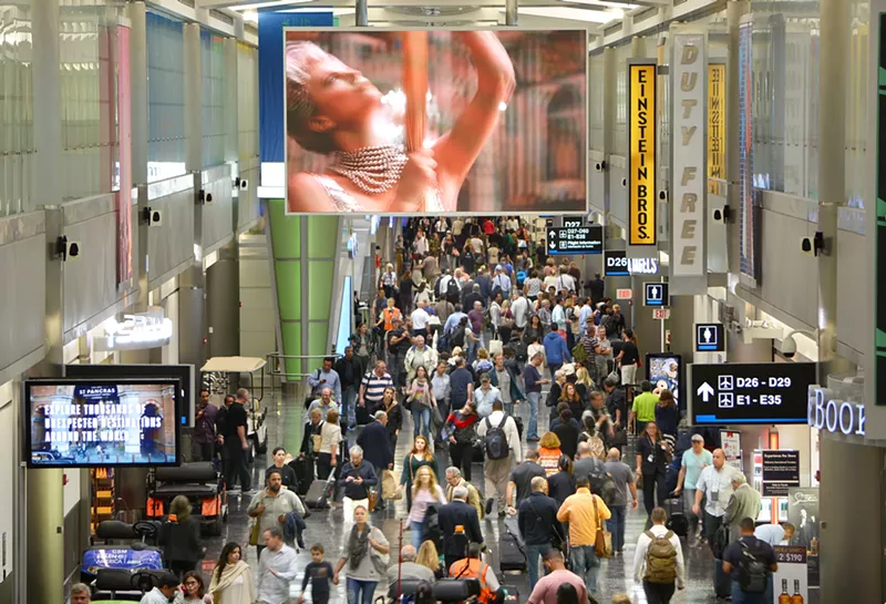 Image: A crowded terminal at Miami International Airport (MIA) with passengers walking through Concourse D, showcasing the airport’s heavy traffic and growing demand