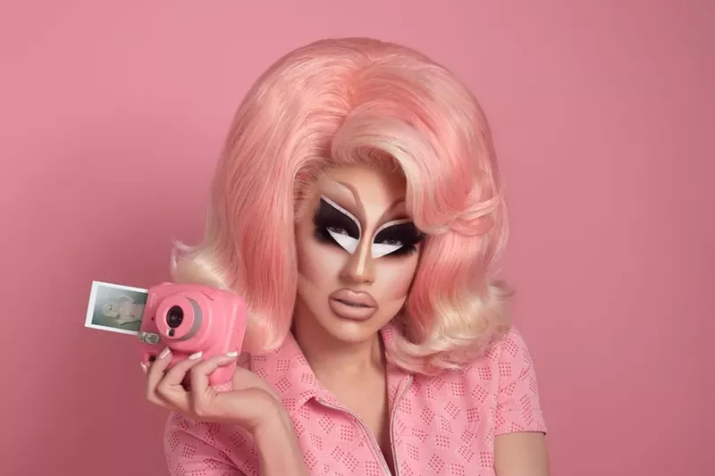 Image: Trixie Mattel dressed in pink holding a camera