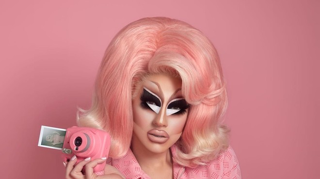 Trixie Mattel dressed in pink holding a camera