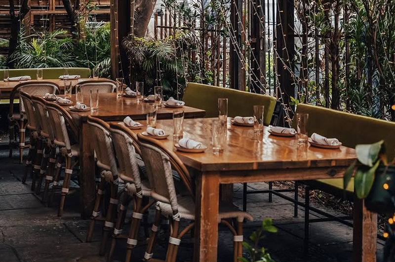 Image: an outdoor dining area with greenery