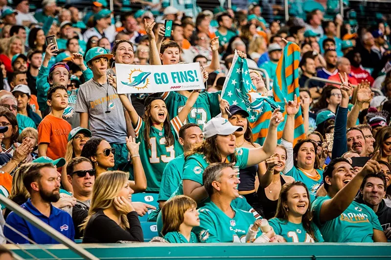 Image: Dolphins fans wearing teal jerseys in the stands at Hard Rock Stadium.