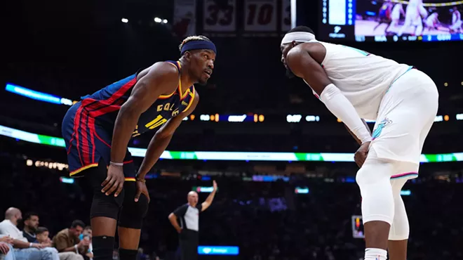 Jimmy Butler III #10 of the Golden State Warriors and Bam Adebayo #13 of the Miami Heat on the court during the first quarter at Kaseya Center on March 25, 2025, in Miami, Florida.