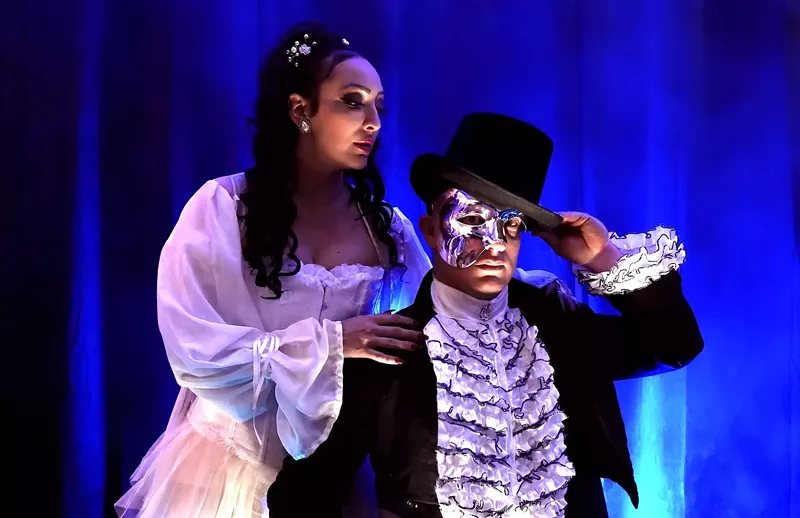 Image: A well-dressed man and woman performing on a stage