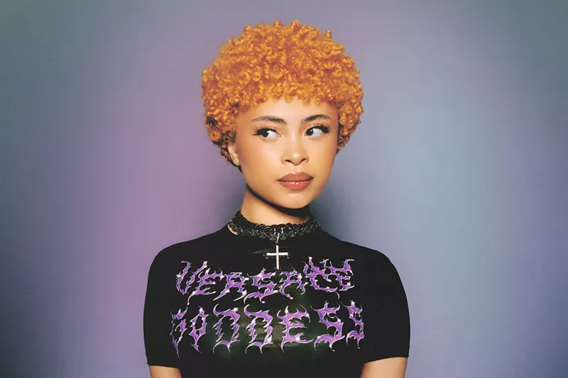 Image: Portrait of Ice Spice in a bright orange Afro