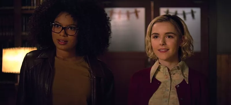 Image: Kiernan Shipka (right) stars as America’s favorite teenage witch, who talks casually of patriarchy and intersectionality with her best friend Roz (Jaz Sinclair), in Netflix’s Chilling Adventures of Sabrina.