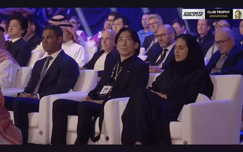Image: dignitaries in comfy white armchairs at a fancy ceremony