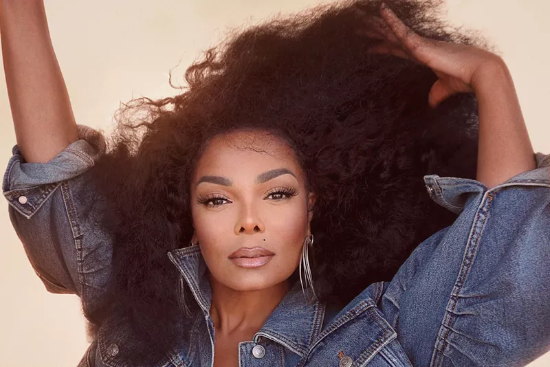 Image: Janet Jackson starring at the camera while brushing her hair with her fingers
