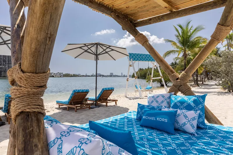 Image: A beach club with blue chairs facing the ocean