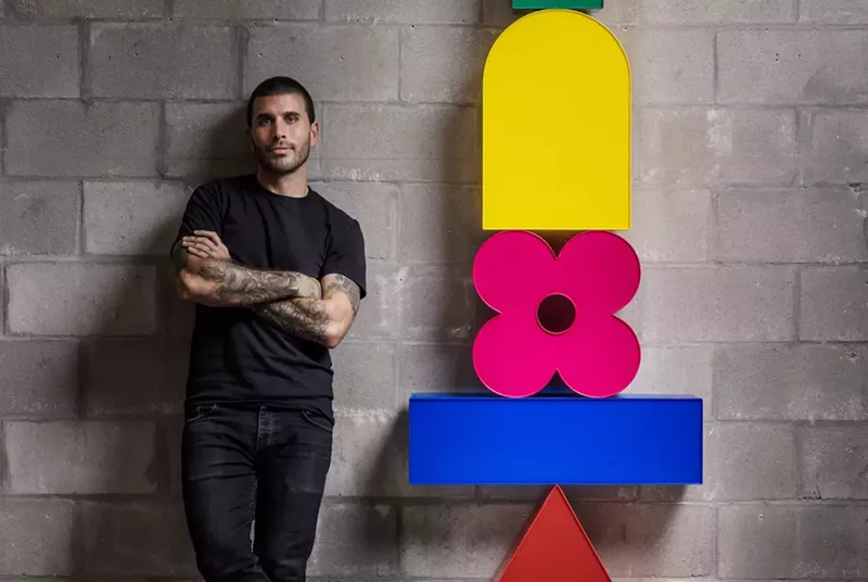 Image: Typoe stands with a sculpture featured in his solo exhibition, "Die Form."