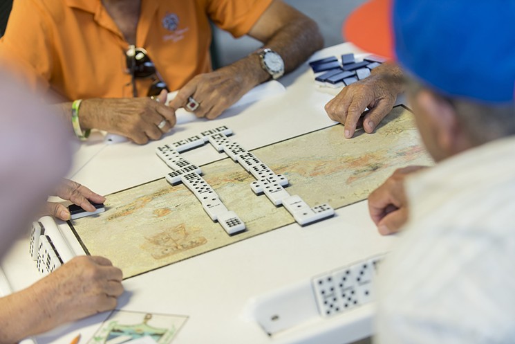 Domino players at work in Calle Ocho's M&aacute;ximo G&oacute;mez Park. - PHOTO BY ALEX MARKOW