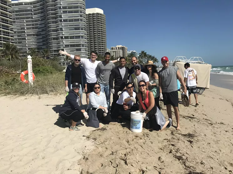 Volunteers pick up plastic straws and other litter at a beach cleanup in Surfside. - COURTESY OF JENNIFER ROTKER