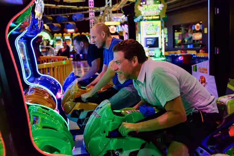 A group of men playing arcade games at Xtreme Action Park