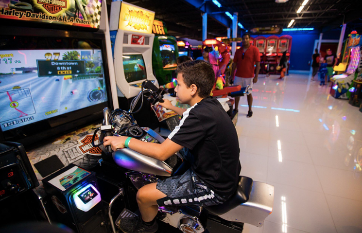 A young boy playing an arcade game