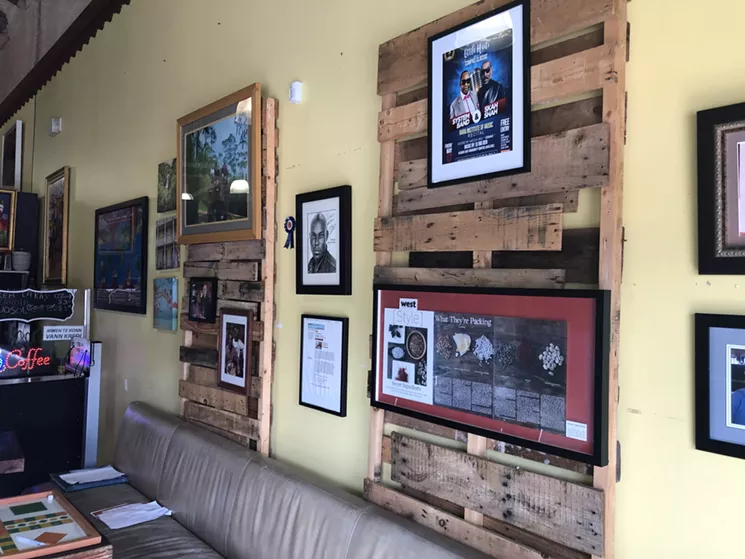 Past articles and pictures of famous guests hang on the wall of George Laguerre's coffee shop, Tigeorges Kafe, in Little Haiti. - PHOTO BY TAMICA JEAN-CHARLES