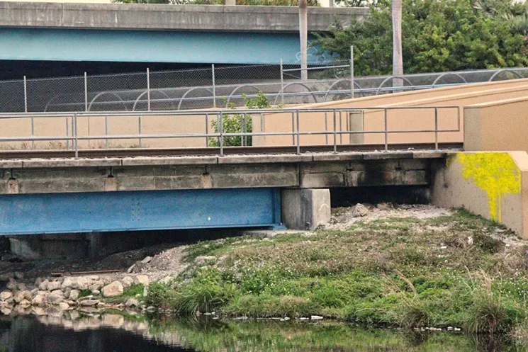 A homeless camp was set ablaze, then cleared out, near the site of a proposed $2 million Okeechobee Metrorail pedestrian bridge. - PHOTO BY THEO KARANTSALIS