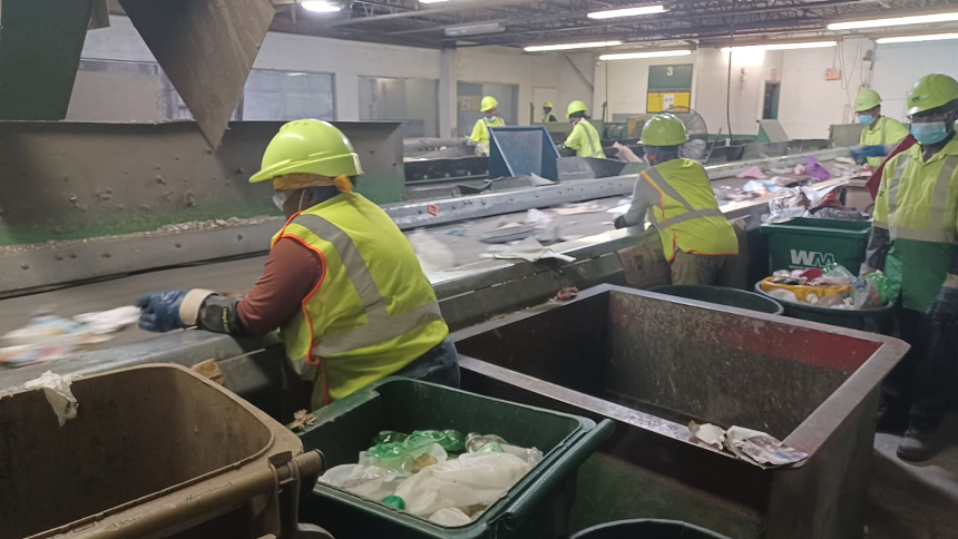 Workers sort through recyclable material on a conveyor belt, taking out contaminated or unusable items and prioritizing the more valuable materials. - PHOTO BY JOSHUA CEBALLOS