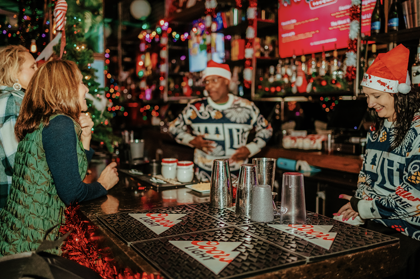 Tinsel Tavern inside of Vivo! Christmas Village at Dolphin Mall is filled with holiday decorations, bartenders decked up in Santa Claus hats, and festive cocktails.