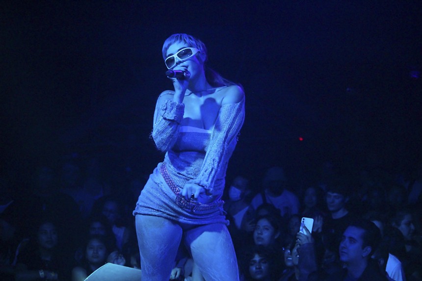 MJ Nebreda, bathed in a blue light, performing on stage