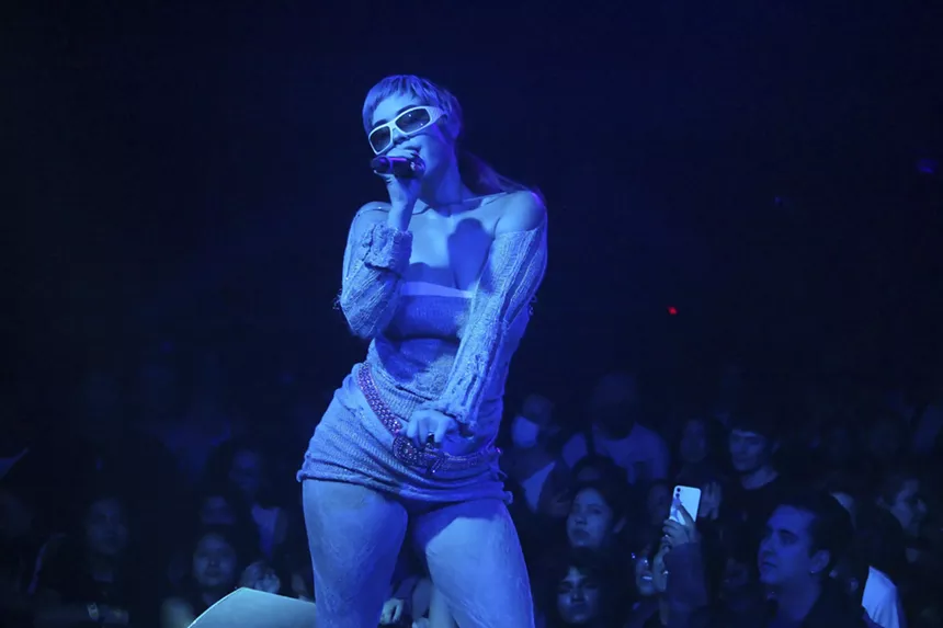 MJ Nebreda, bathed in a blue light, performing on stage