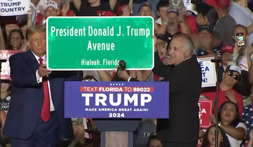 Hialeah Mayor Esteban "Steve" Bovo lifts a street sign designating President Donald J. Trump Avenue.