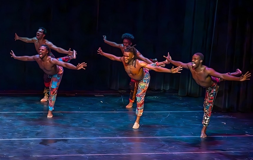 Dancers on stage leaning forward with hands extended