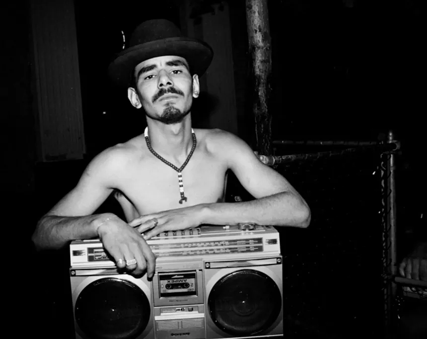 Shirtless man holding a boombox