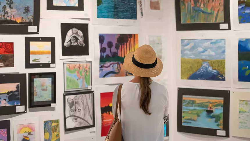 Woman looks at art hung on the walls